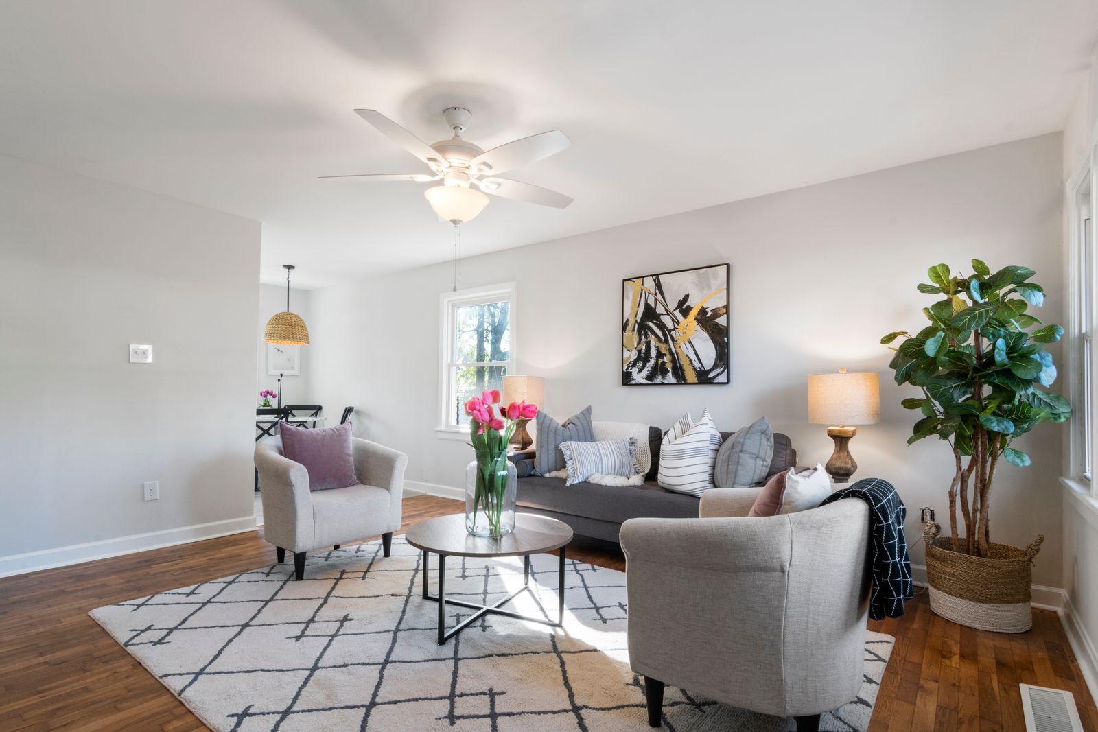 Bright modern living room with neutral furniture and wood floors