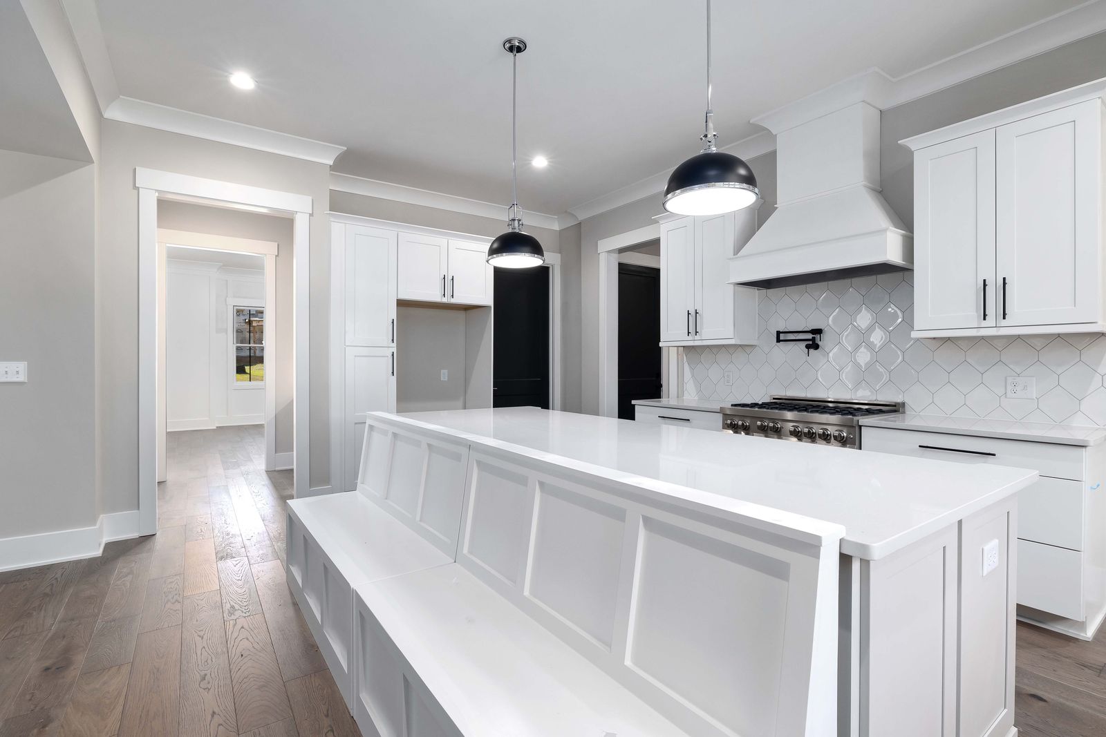 Sleek white remodeled kitchen with pendant lighting