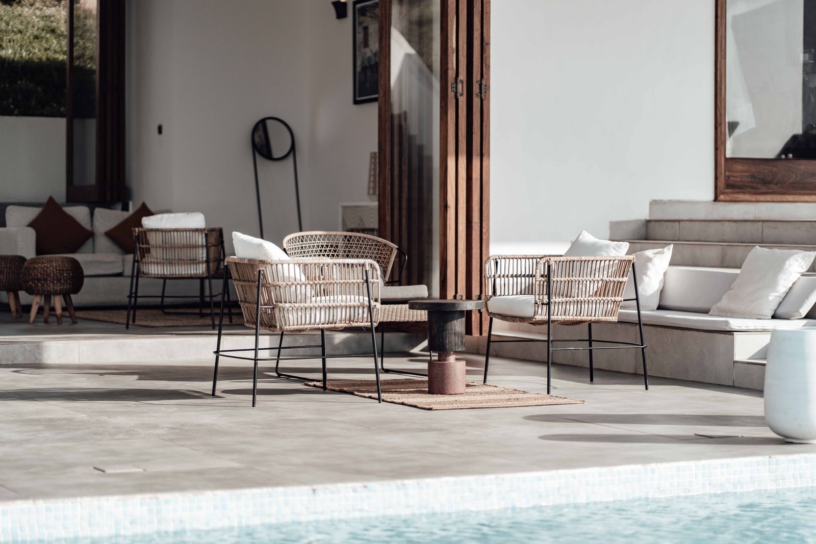 Poolside lanai seating with modern wicker chairs and cushions