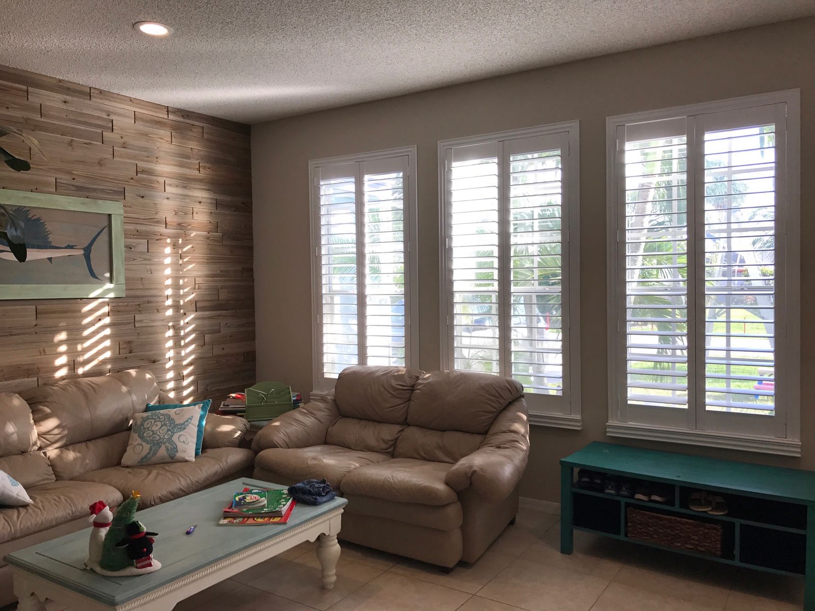 Bright minimalist living room with beige sofas and wood paneling