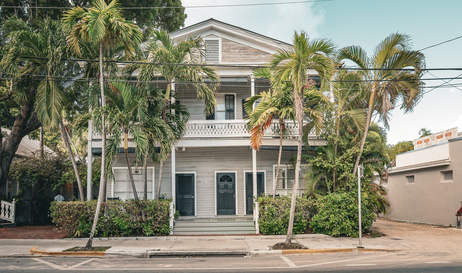 Key West style Florida cottage framed by palm trees